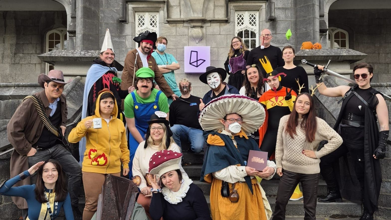 A diverse group of smiling people in imaginative costumes, enjoying a playful moment at a themed party or event.