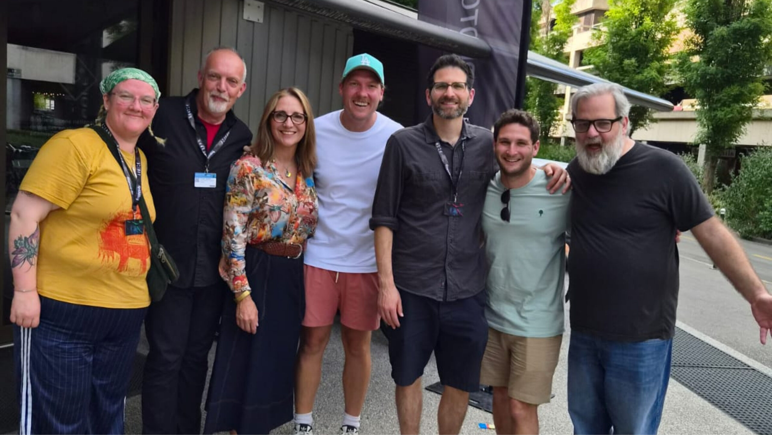 A group of people stand smiling facing the camera. 